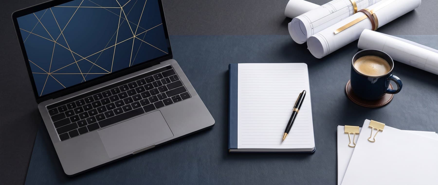 Laptop and notebook on a desk, ready for the latest company updates